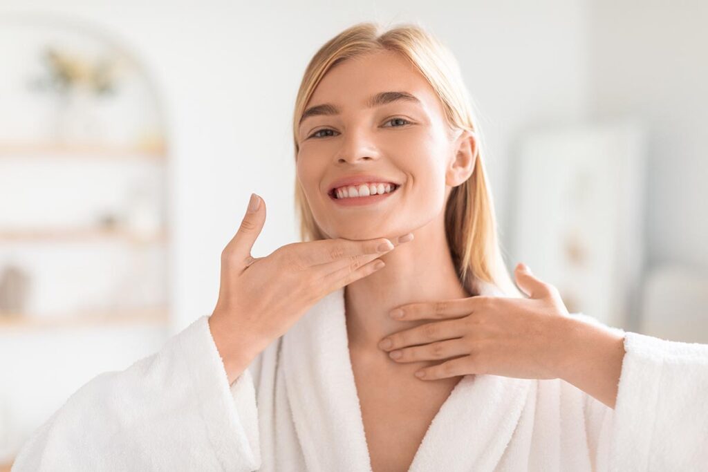 Woman touching chin after HIFU treatment for post-pregnancy double chin reduction