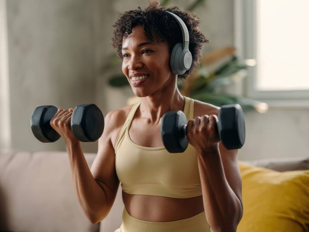 Woman lifting dumbbells at home for physician-guided weight loss and lasting results